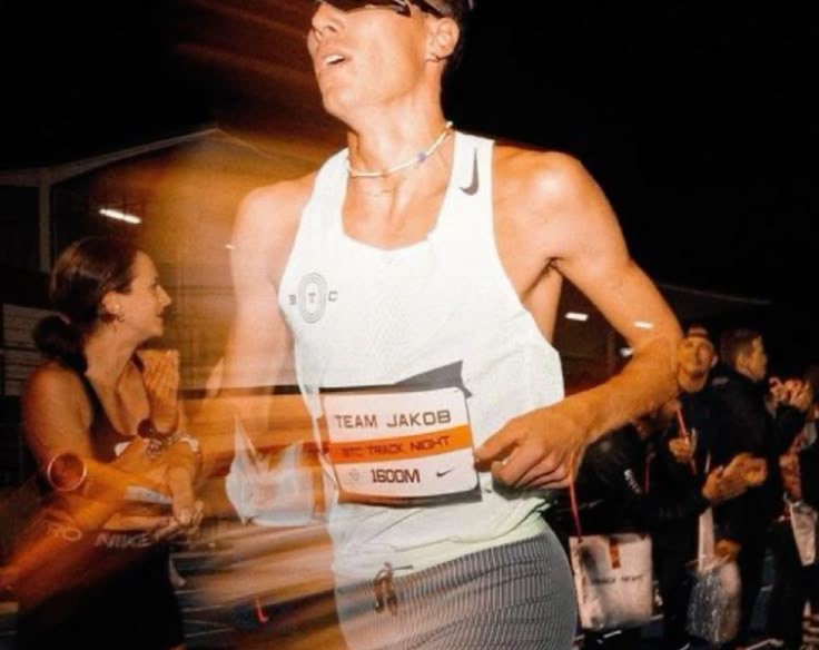 Pelari serius 10K dengan nomor dada di tengah kerumunan peserta